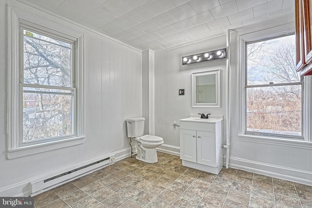 bathroom with a healthy amount of sunlight, toilet, and baseboard heating