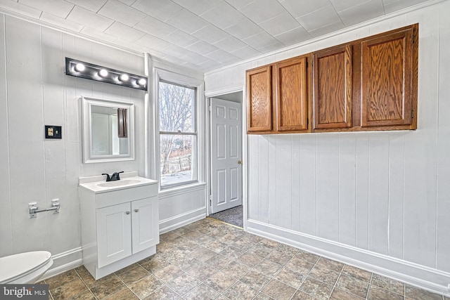 bathroom with baseboards, vanity, and toilet