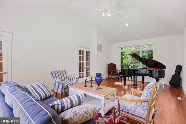 living area with french doors, visible vents, wood finished floors, high vaulted ceiling, and baseboards