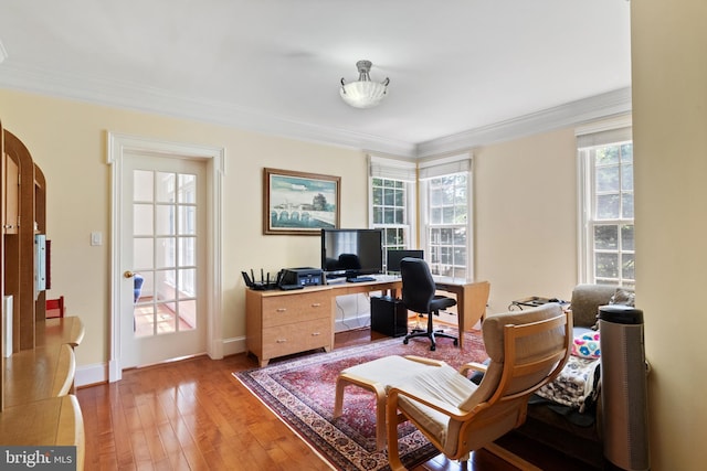 office with light wood-style floors, baseboards, arched walkways, and crown molding