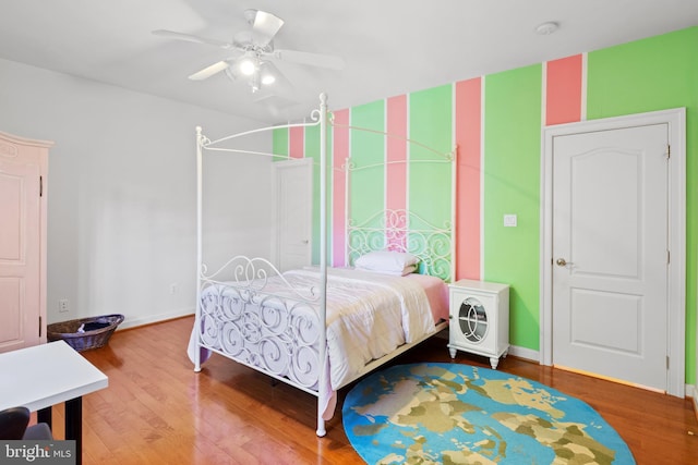 bedroom with ceiling fan, baseboards, and wood finished floors