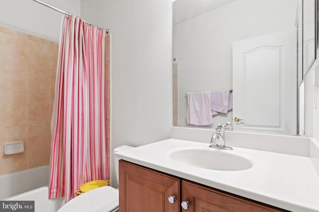 bathroom with shower / tub combo with curtain, vanity, and toilet