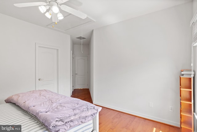 bedroom with visible vents, a ceiling fan, baseboards, light wood-type flooring, and attic access