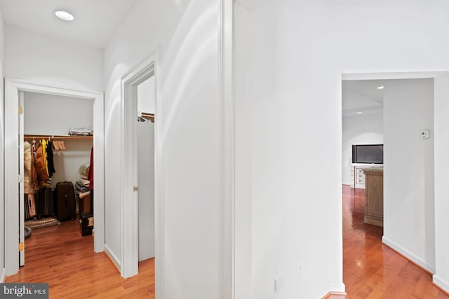 hall featuring light wood finished floors and recessed lighting