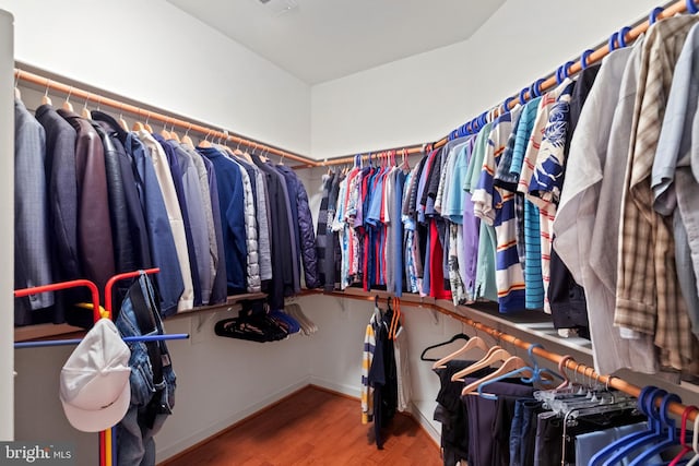 walk in closet with wood finished floors