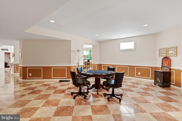 dining room with a decorative wall, wainscoting, and recessed lighting