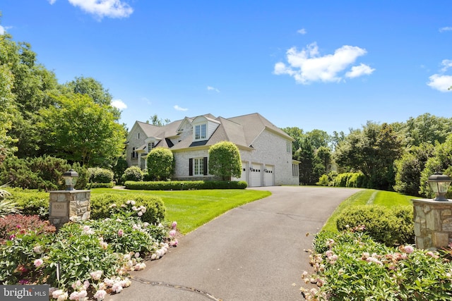 view of front facade featuring driveway, a garage, and a front lawn