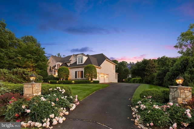 view of front of home featuring a garage, driveway, and a lawn