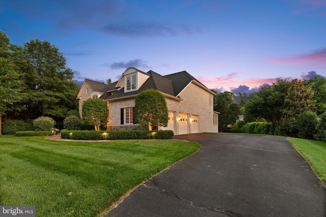 view of front facade with driveway, a front lawn, and stone siding