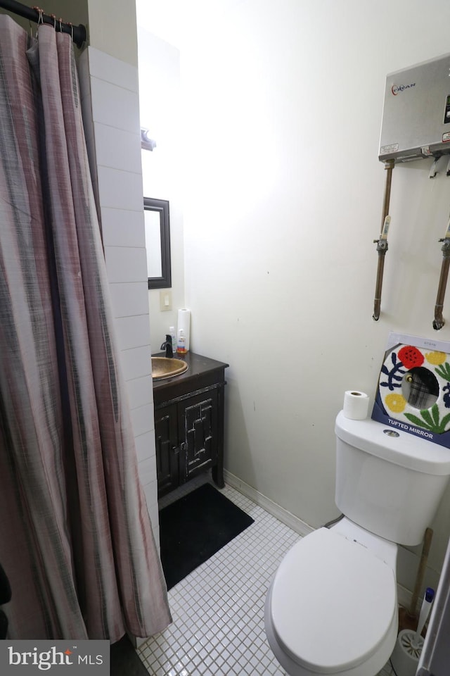 bathroom featuring toilet, tile patterned flooring, baseboards, and vanity