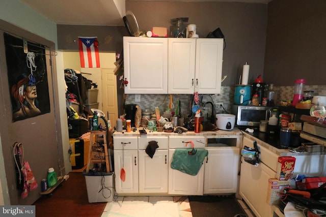 kitchen with decorative backsplash, white cabinets, and light countertops