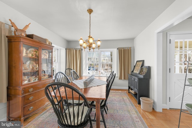 dining space featuring baseboards and an inviting chandelier