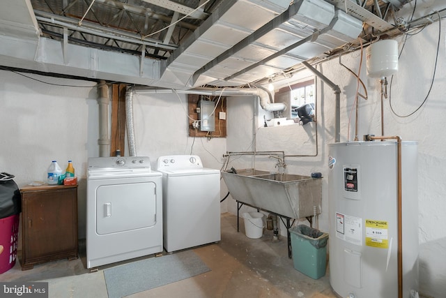 clothes washing area featuring a sink, laundry area, water heater, and washer and dryer