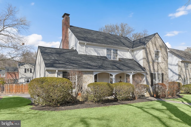 view of side of home featuring a chimney, fence, a lawn, and roof with shingles