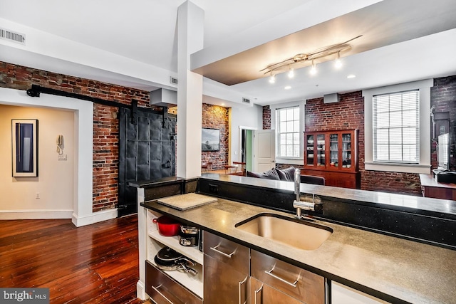 kitchen with brick wall and a sink