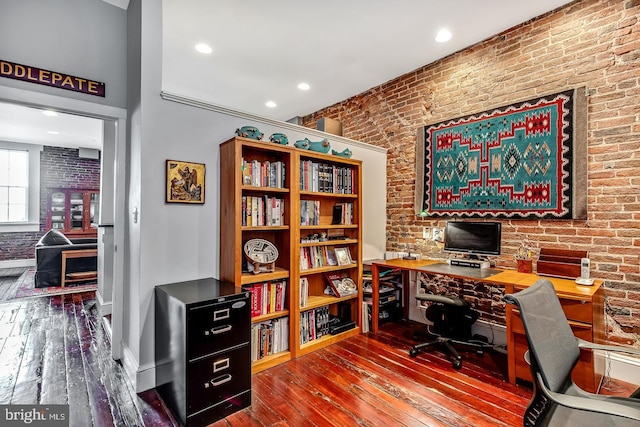 office featuring recessed lighting, wood-type flooring, and brick wall