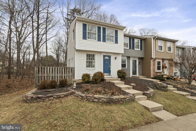 view of front of property with brick siding and fence