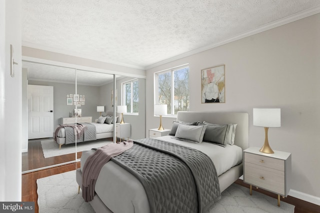 bedroom featuring a textured ceiling, ornamental molding, a closet, and wood finished floors