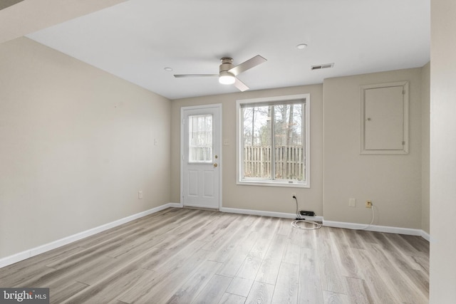 unfurnished room with light wood finished floors, baseboards, visible vents, and ceiling fan