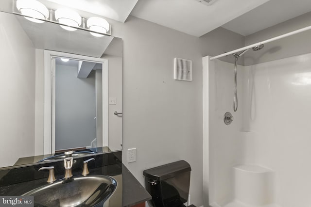 bathroom featuring visible vents, a shower, and vanity