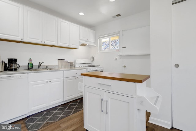 kitchen with white appliances, visible vents, dark wood-style flooring, white cabinetry, and a sink