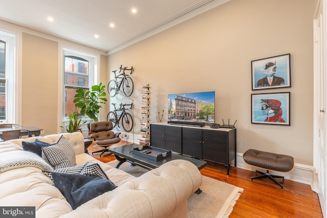 living room with crown molding, baseboards, wood finished floors, and recessed lighting