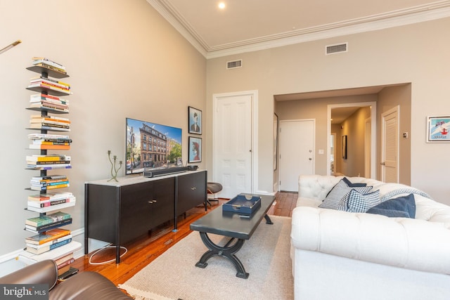 living room featuring ornamental molding, visible vents, and wood finished floors