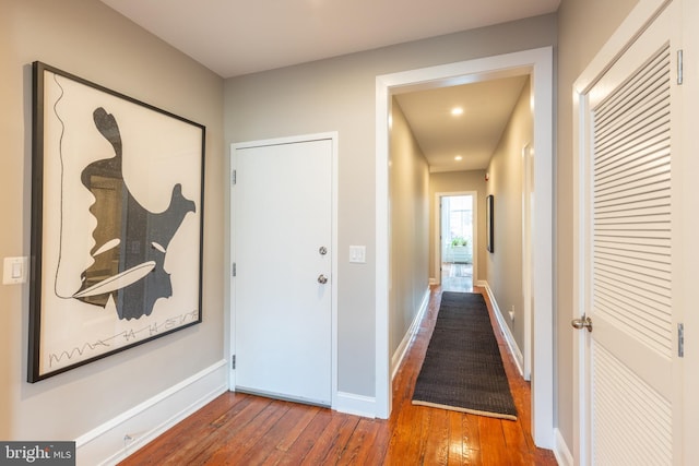 corridor with hardwood / wood-style flooring and baseboards