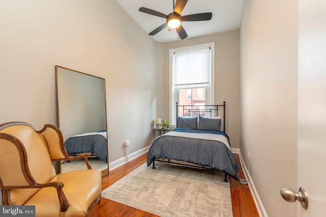 bedroom featuring ceiling fan, baseboards, and wood finished floors