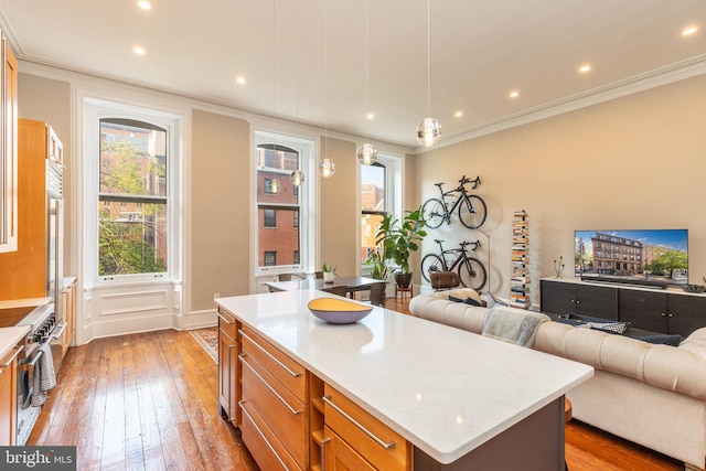 kitchen featuring crown molding, light wood-style floors, brown cabinetry, and double oven range