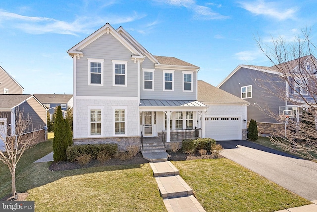 view of front of house with a garage, aphalt driveway, covered porch, a standing seam roof, and a front yard