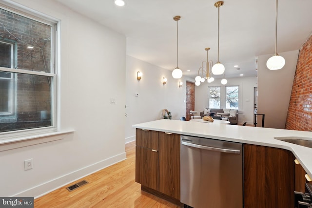 kitchen with visible vents, light countertops, stainless steel dishwasher, modern cabinets, and decorative light fixtures