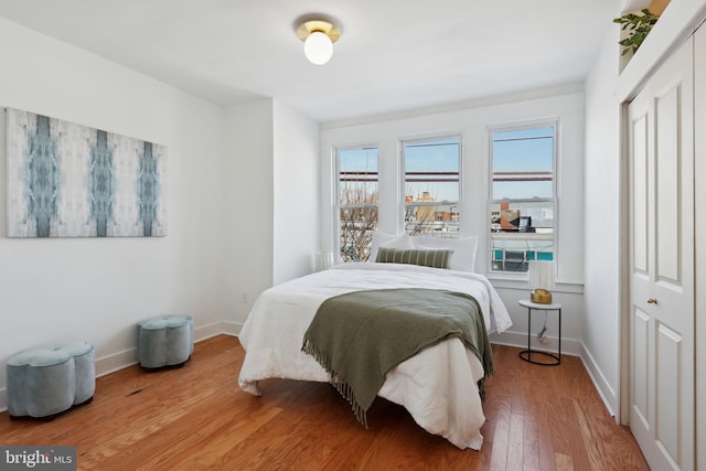 bedroom featuring a closet, baseboards, and wood finished floors