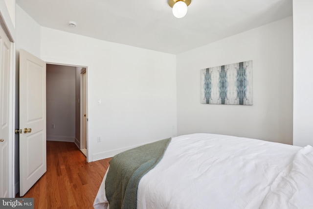 bedroom featuring wood finished floors and baseboards