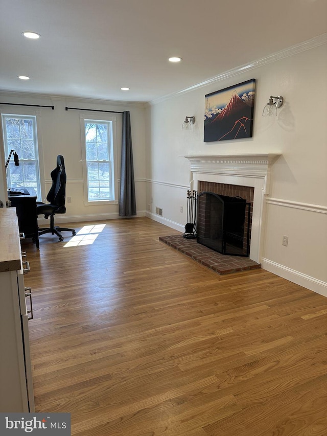 office with ornamental molding, a brick fireplace, wood finished floors, and recessed lighting