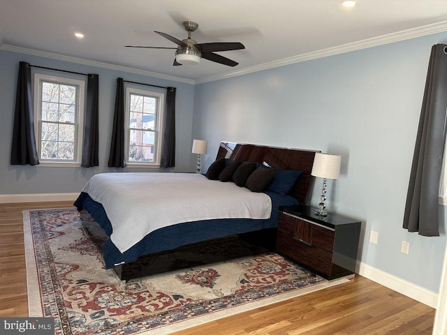 bedroom featuring baseboards, light wood-type flooring, a ceiling fan, and crown molding