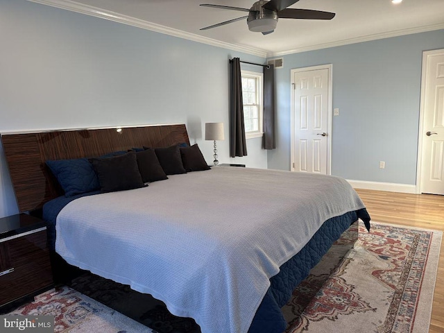 bedroom with baseboards, ornamental molding, ceiling fan, and wood finished floors