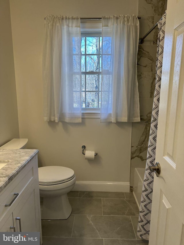 bathroom with shower / tub combination, vanity, toilet, and baseboards