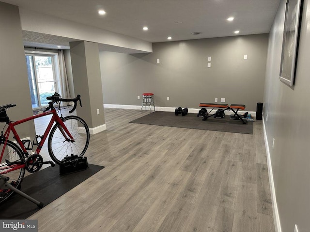 workout room with baseboards, wood finished floors, and recessed lighting