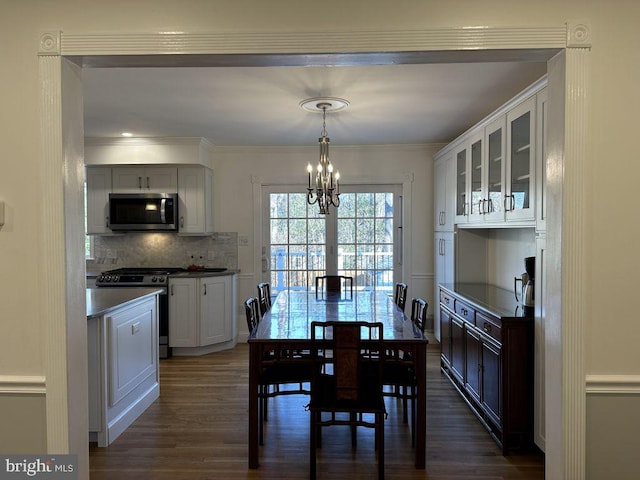 dining room featuring ornamental molding, dark wood-style flooring, and a notable chandelier