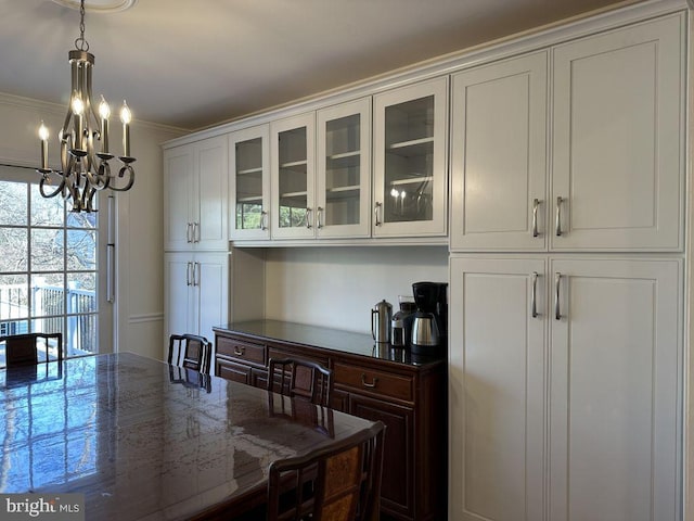 dining area with ornamental molding and a notable chandelier