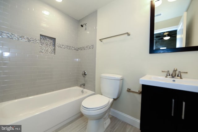 bathroom featuring toilet, bathtub / shower combination, baseboards, and vanity