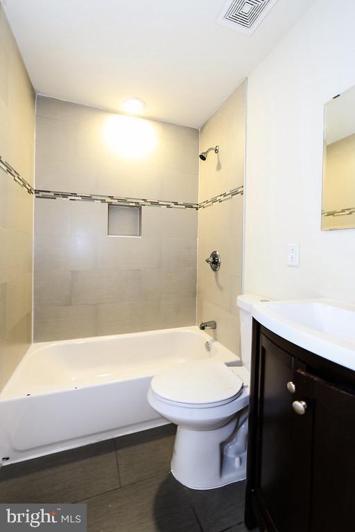 full bath featuring visible vents, vanity, toilet, and shower / bathtub combination