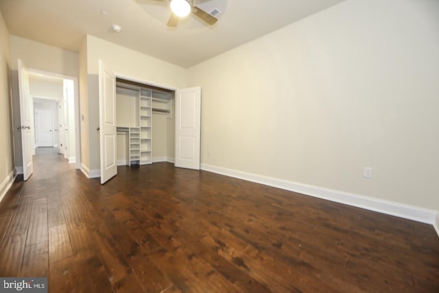 unfurnished bedroom with a ceiling fan, baseboards, dark wood finished floors, and a closet