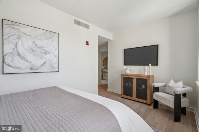 bedroom with visible vents and wood finished floors