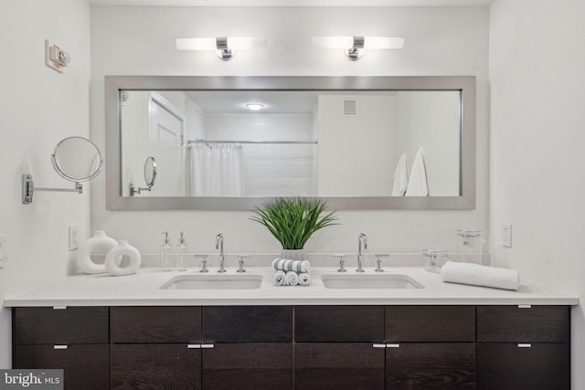 bathroom with a sink, visible vents, a shower with shower curtain, and double vanity