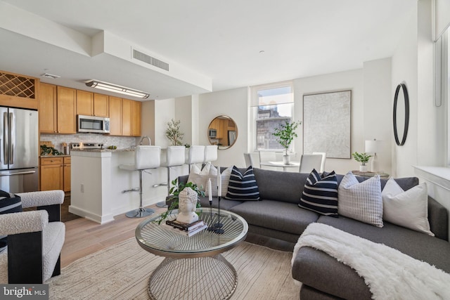 living area with visible vents and light wood-style flooring