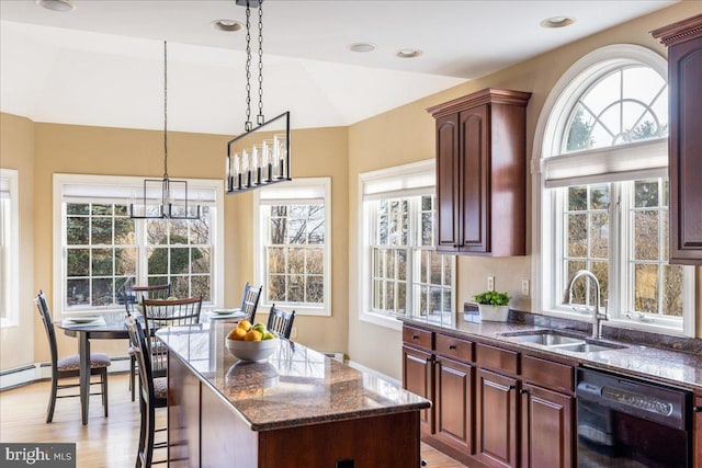 kitchen featuring light wood-type flooring, black dishwasher, vaulted ceiling, dark stone countertops, and a sink