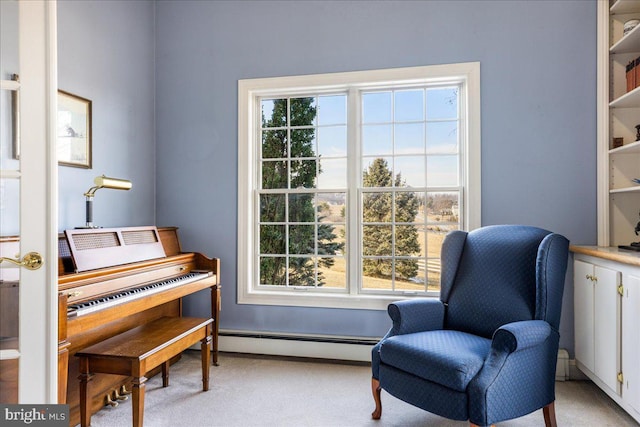 sitting room with a baseboard heating unit and light carpet