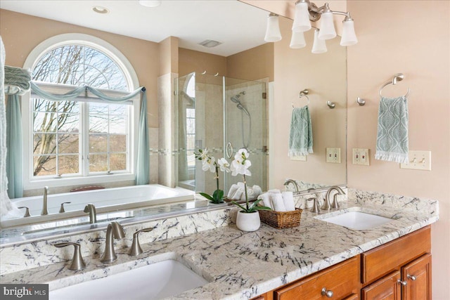 full bath with a sink, visible vents, a stall shower, and double vanity